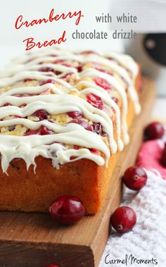 cranberry bread with white chocolate drizzle on a cutting board next to some cranberries