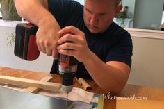 a man is using a drill to fix a piece of wood with a power tool