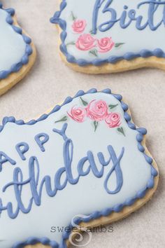 decorated cookies with blue icing and pink flowers on them that say, happy birthday