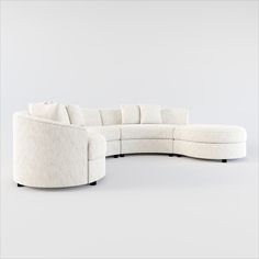 a large white sectional couch sitting on top of a white floor next to a wall