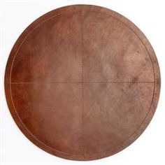 a round leather table top with stitching on the edges and four circles at the center