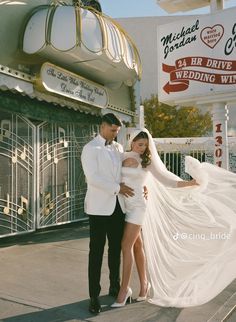 a man and woman standing next to each other in front of a building with signs on it