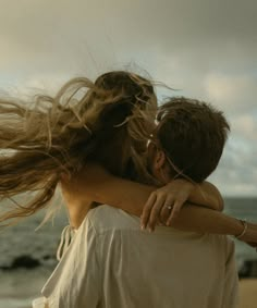 two people embracing each other on the beach