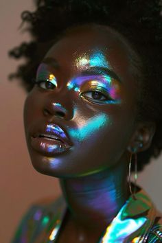 a woman with bright makeup and holographics on her face