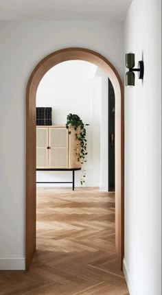 an arch leading into a living room with wood floors