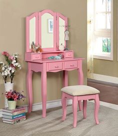 a pink dressing table with mirror and stool