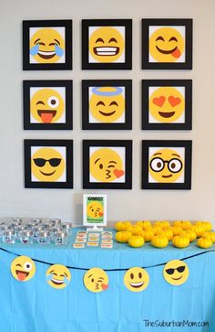 a table topped with lemons next to pictures of smiley faces on the wall behind it