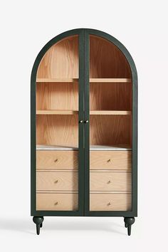 an arch shaped cabinet with drawers and shelves