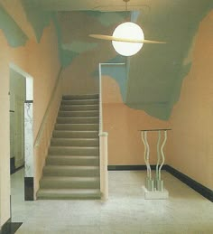 an empty room with some stairs painted on the wall and a round light hanging from the ceiling