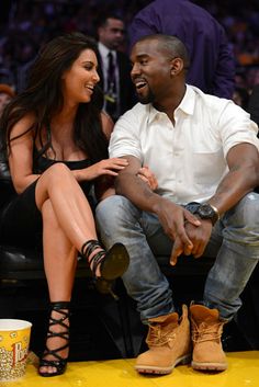 a man and woman sitting next to each other on a bench at a basketball game