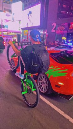 a man riding a bike down the middle of a street in front of some cars