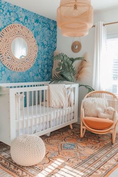 a baby's room with blue wallpaper and white crib in the corner