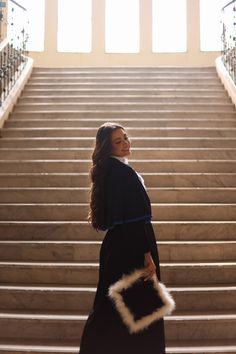 a woman is walking down the stairs with her handbag in front of her face