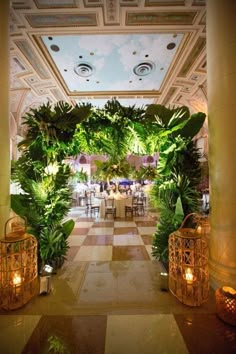 the inside of a building decorated with plants and lanterns on either side of the entrance