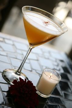 a drink sitting on top of a computer keyboard next to a glass filled with liquid