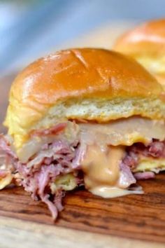 a close up of a sandwich on a cutting board with meat and cheese in the middle