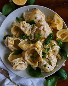 a white plate topped with pasta and lemon slices