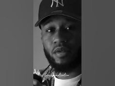 a black and white photo of a man wearing a baseball cap