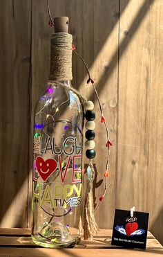 Beautiful LED lighted clear recycled wine bottle with an inspirational message: "Live, Laugh, Love, Happy Times" and a wood tassel with metal tag: "Fe, Esperanza, Amor" LED lights are battery powered. This makes a great gift for friends and family alike, a perfect housewarming present, but make sure to get one for yourself! ❤ MADE ESPECIALLY FOR YOU: Due to different screen color variations from phones, iPads and computers, colors may vary from the original photo. Each product is handmade and while every effort is made to ensure a perfect end result, there may be minor imperfections. ❤ CUSTOM: We're happy to create custom products. If you'd like something different please reach out. ❤ PROCESSING TIME: Please allow 1 week for production and shipping. ❤ GIFTS: We can ship our products direct Happy Times Quotes, Wine Bottle Lamp, Recycled Wine Bottle, Times Quotes, Metal Tag, Lighted Wine Bottles, Happy Times, Screen Color, Bottle Lamp