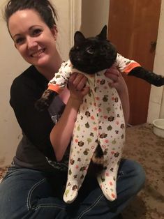 a woman holding a black cat in her arms and the caption says, i don't know what this is