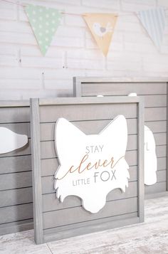 a sign that says stay clever little fox on the side of a wooden box in front of a white brick wall