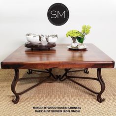 a wooden table with two plates on it and flowers in vases at the top