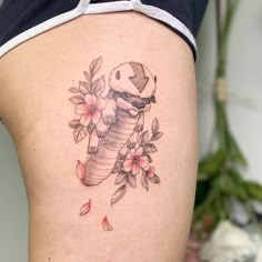 a woman's thigh with a snake and flowers tattoo on her side ribcage