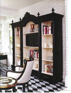 a black and white checkered floor with bookshelves in the middle, chairs on either side