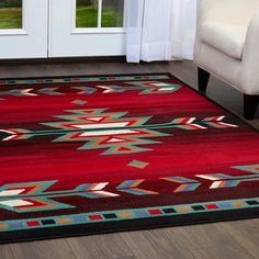 a red area rug with an arrow design on it in front of a white door