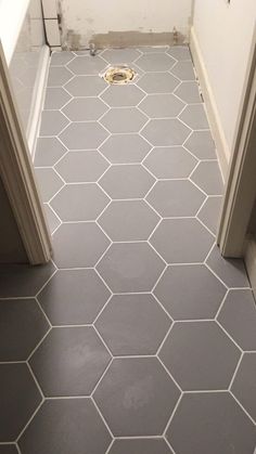 an open door leading to a bathroom with hexagonal tiles