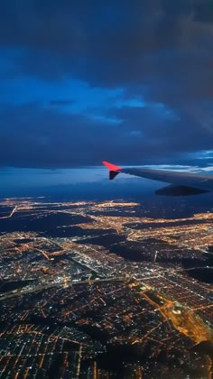 an airplane wing flying over a city at night