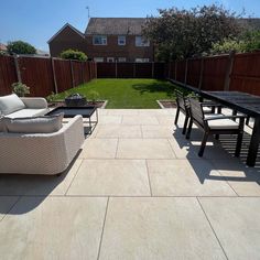 an outdoor patio area with chairs, table and couches in the middle of it