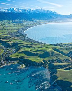 an aerial view of the ocean, mountains and houses in new zealand's north island