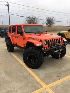 an orange jeep parked in a parking lot