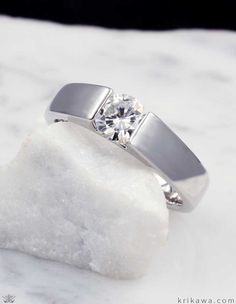 a diamond ring sitting on top of a rock