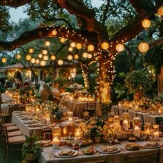 an outdoor dinner table set up with candles and lights