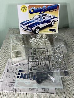 an old model car in plastic packaging next to it's package on a table