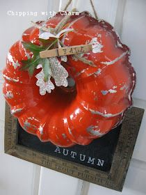 an orange pumpkin hanging from a door with a tag on it's front end