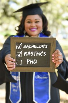 a woman holding up a sign that says bachelor's master's phd