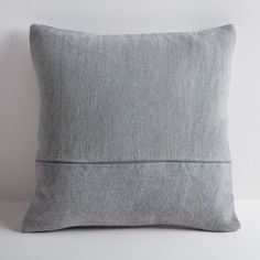 a gray pillow sitting on top of a white table