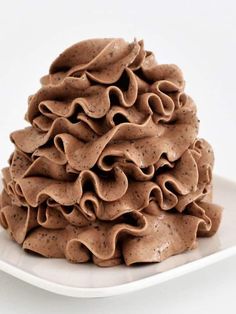 a pile of chocolate frosted cookies on a white plate