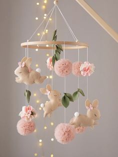 a baby crib mobile with pink pom poms hanging from it's sides