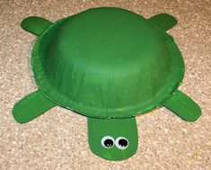 a paper plate turtle on the floor with googly eyes