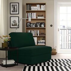 a green chair sitting in front of a book shelf