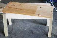 a wooden bench sitting on top of a cement floor