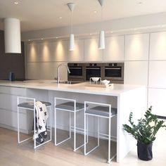 a kitchen with an island and stools next to the stove top oven in it