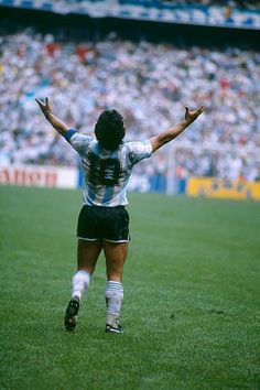 a soccer player is jumping up in the air with his arms wide open as he celebrates