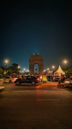 cars are parked in front of the monument at night