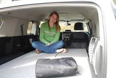 a woman sitting in the back of a white van