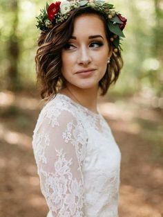 a woman wearing a flower crown standing in the woods with her hands on her hips